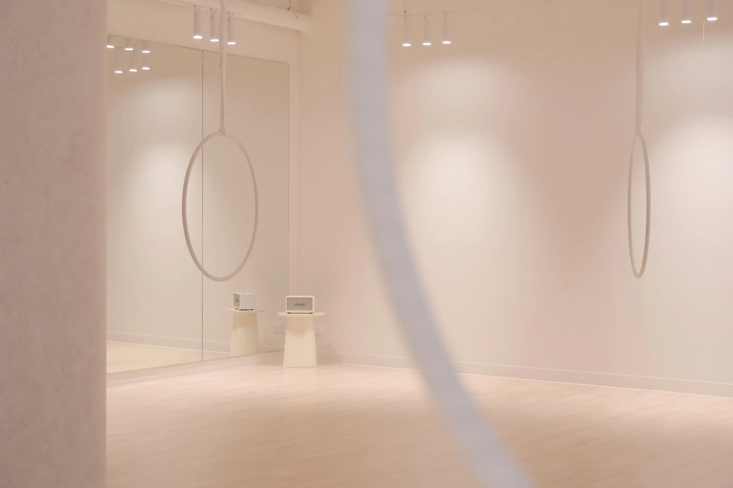 Minimal aerial studio in Melbourne CBD featuring hoop and hammock with cozy tones and open space