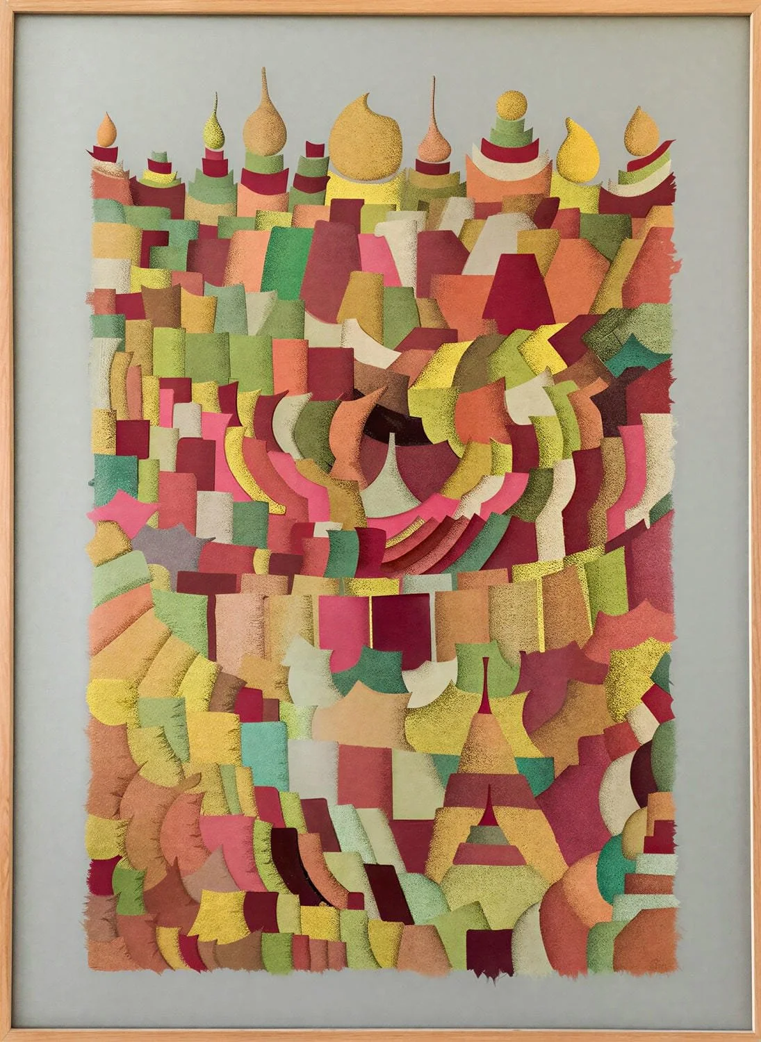 A colorful, abstract collage made of various fabric pieces arranged in a spiral pattern within a wooden frame.