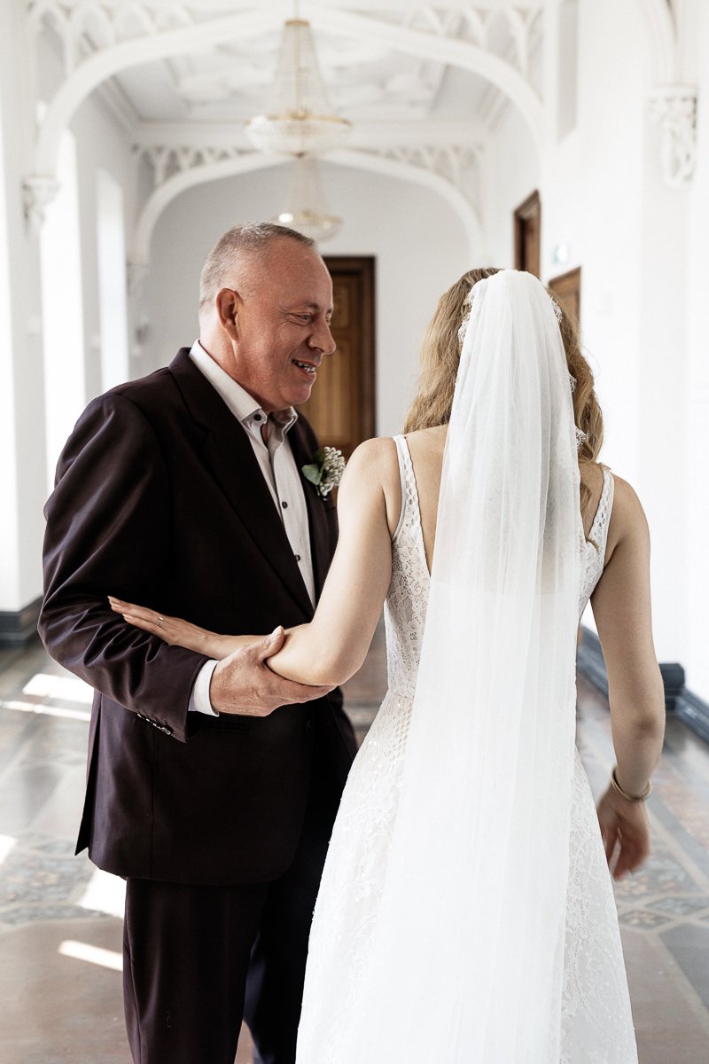 Brautvater sieht die Braut im Schlossflur