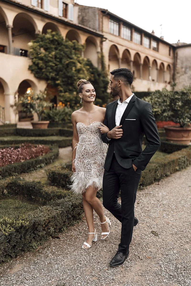 Brautpaar im italienischen Garten, Braut im kurzen Federkleid
