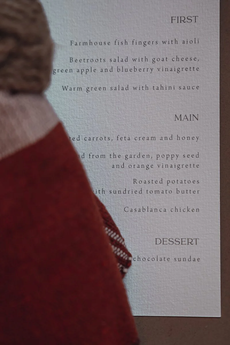 A menu with sections titled 'First,' 'Main,' and 'Dessert.' The 'First' section includes farmhouse fish fingers with aioli, beetroots salad with goat cheese, green apple, and blueberry vinaigrette, and warm green salad with tahini sauce. The 'Main' s