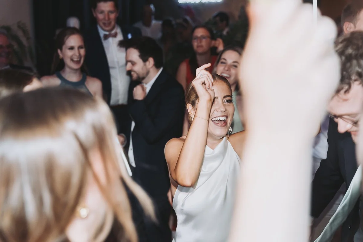 People dancing and celebrating at a social event or party, with smiling and laughing faces.