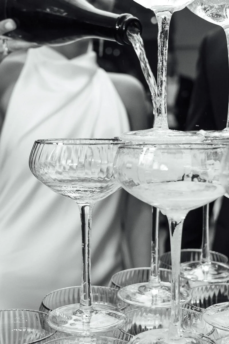 Champagne glasses being filled with a drink from a bottle