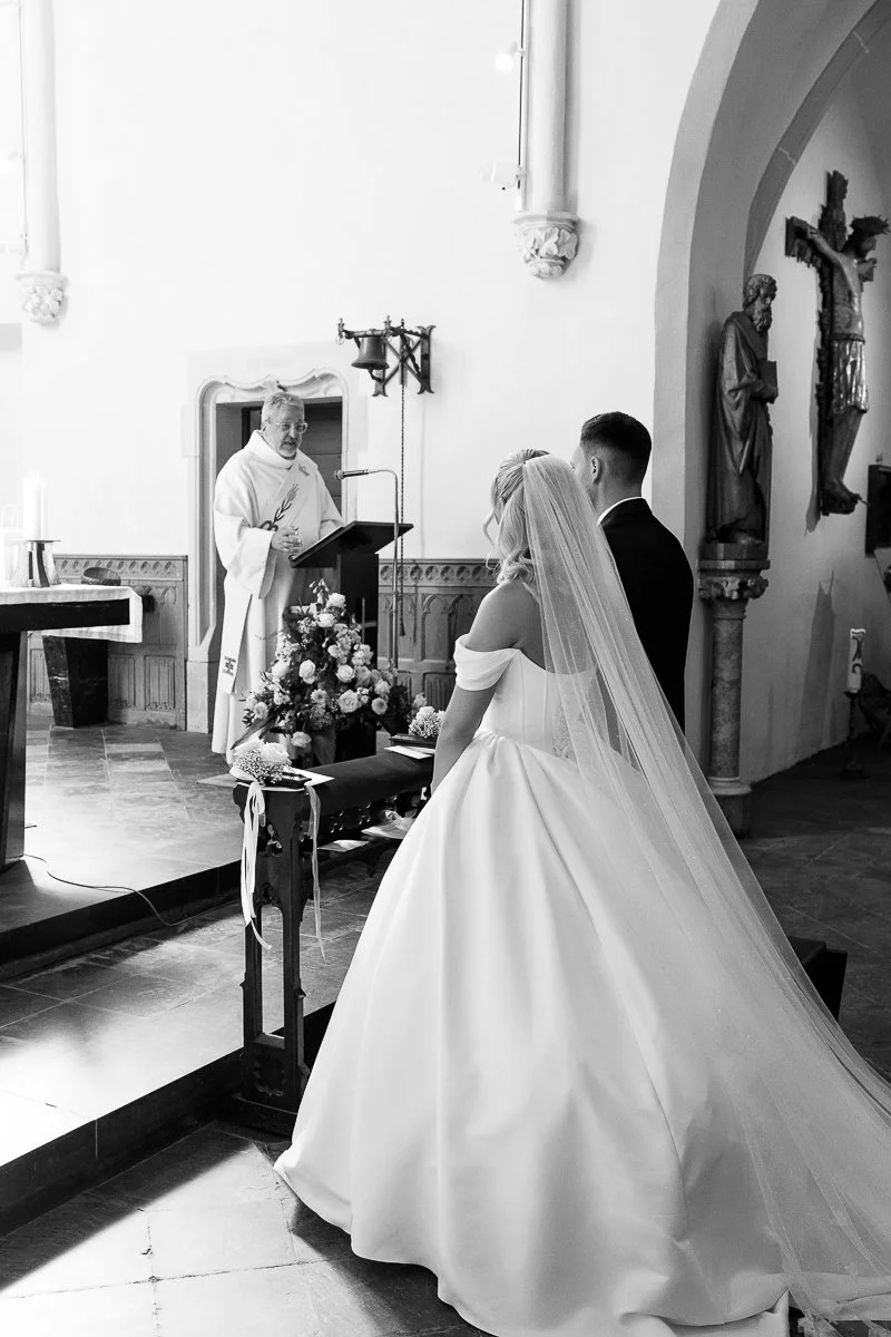 Braut und Bräutigam vor dem Altar, schwarz-weiß