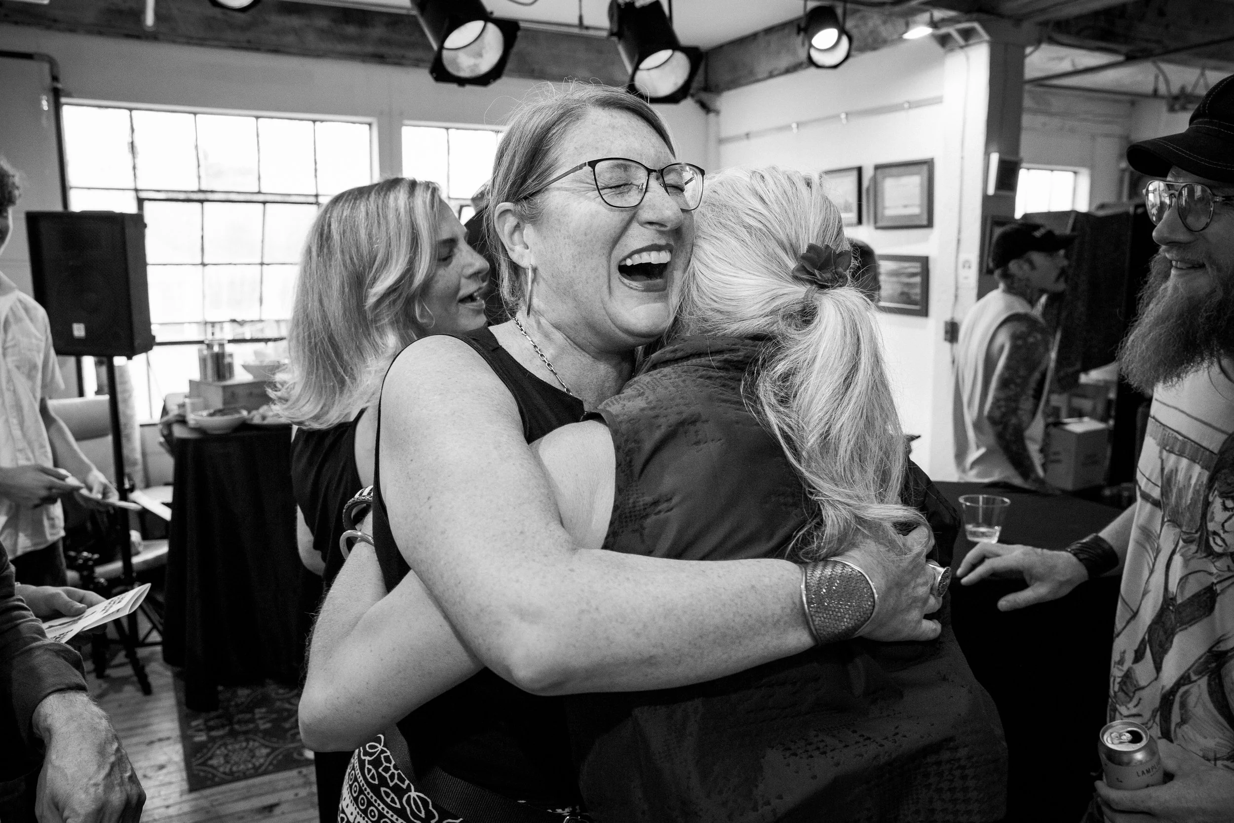 Guests share a joyful embrace during a fashion show in Salem, Massachusetts.