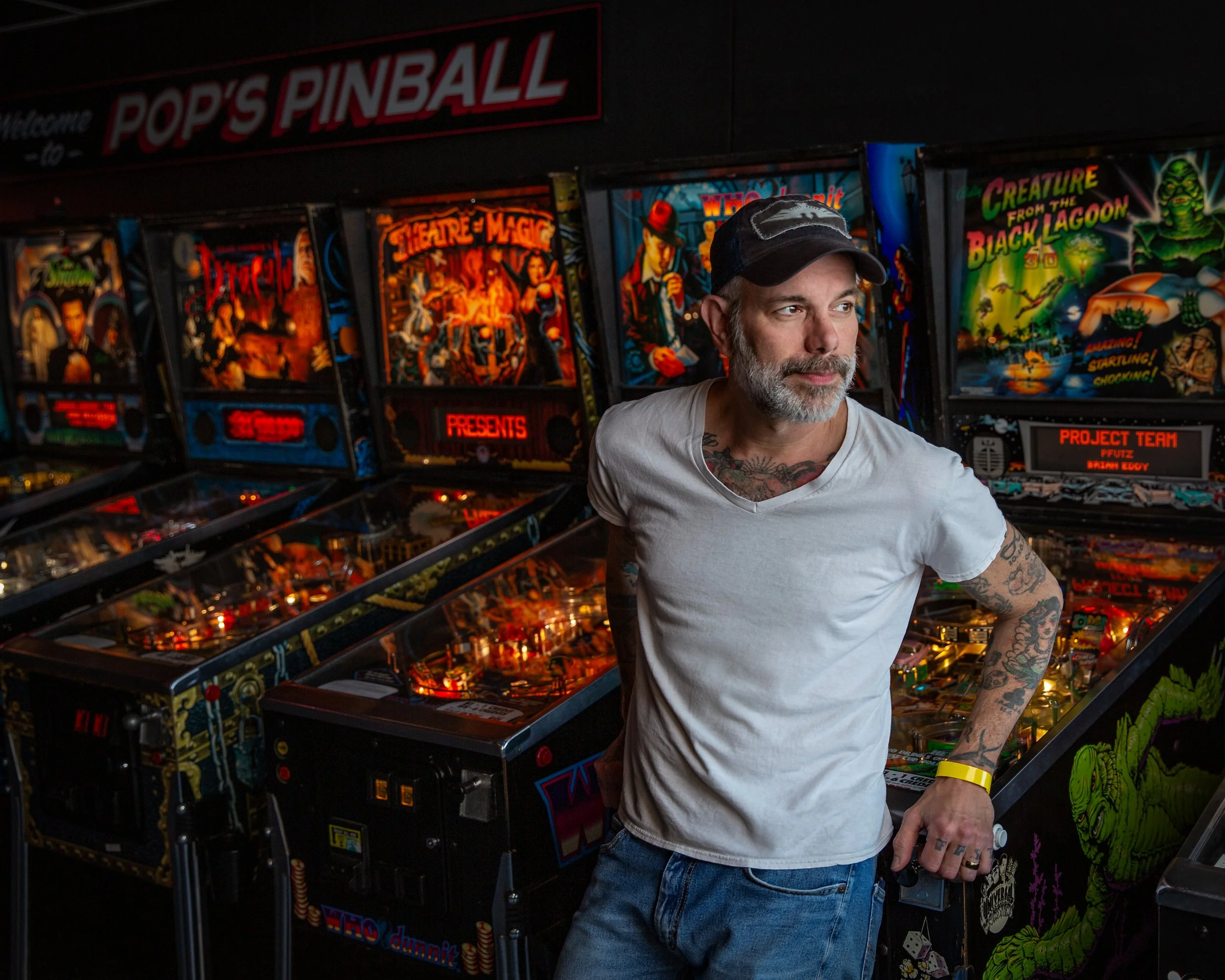 Editorial portrait of musician Ben Nichols standing among vintage pinball machines in an arcade.