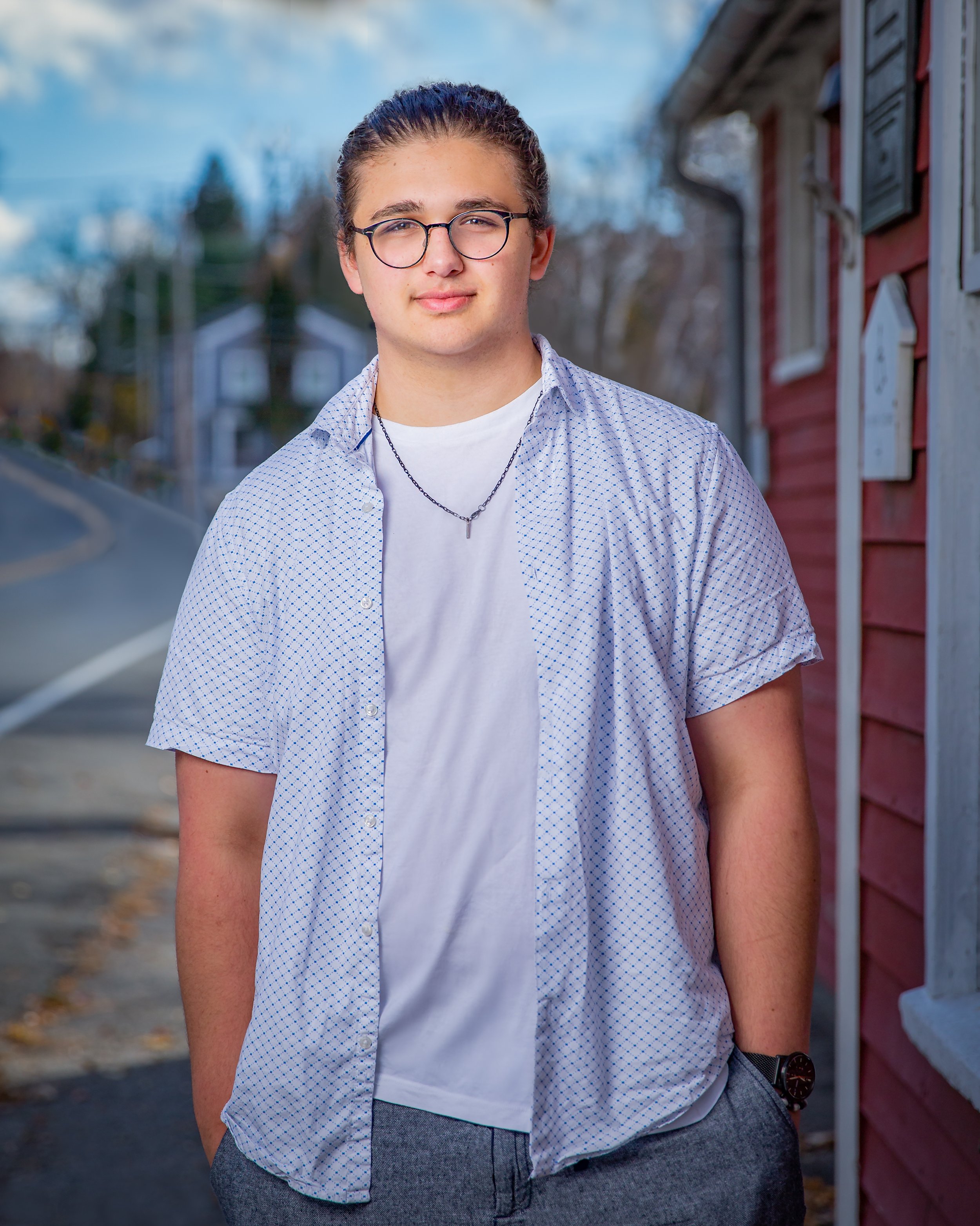 High school senior portrait photographed outdoors in a New England neighborhood with natural light at Lowell's Boat Shop in Amesbury, MA