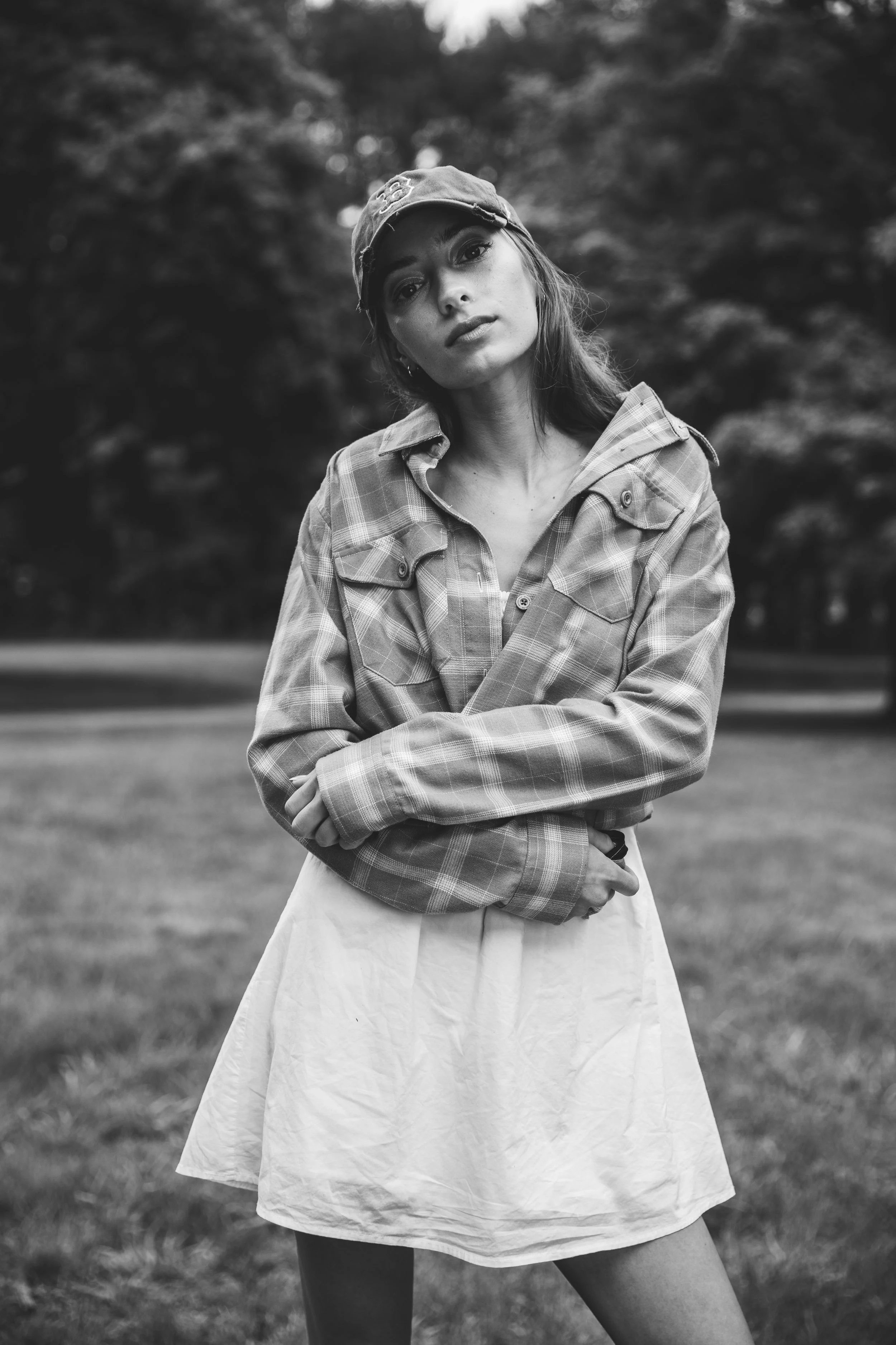 High school senior wearing a RED SOX baseball cap and flannel shirt during an outdoor black-and-white portrait session.