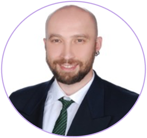 Portrait of a smiling man with a beard, wearing a suit and tie, with an earring, against a purple and white background.
