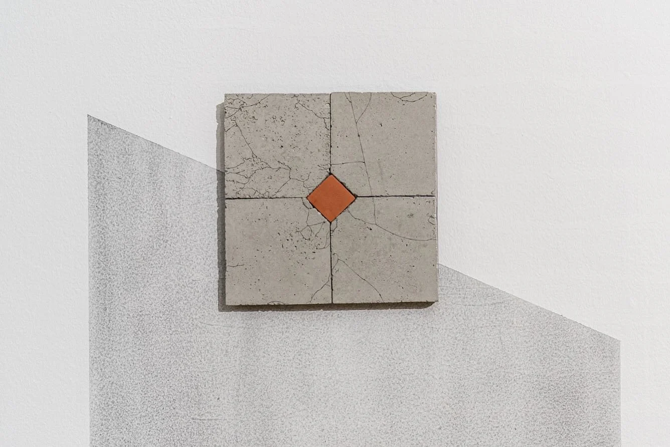 🟧 ✍🏼

&ldquo;Held, beautiful in its simplicity, presents a single small terracotta tile cradled by four weathered concrete tiles showing signs of erosion and time; a composition that quietly stands as a metaphor for the artist, held within the endu