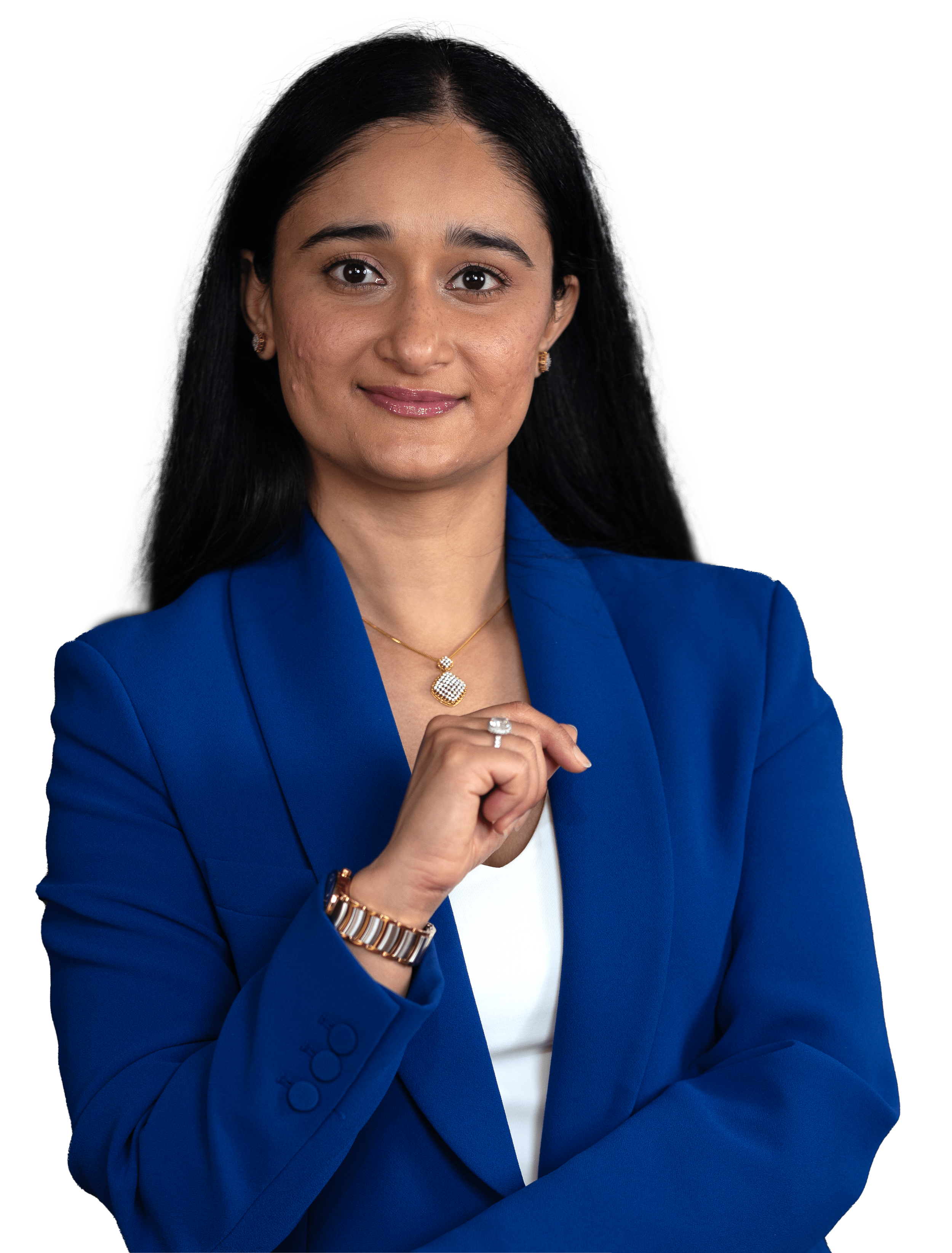 Jeet Bhatti with long black hair wearing a royal blue blazer, white top, gold jewelry, and a watch, posing confidently with a slight smile.