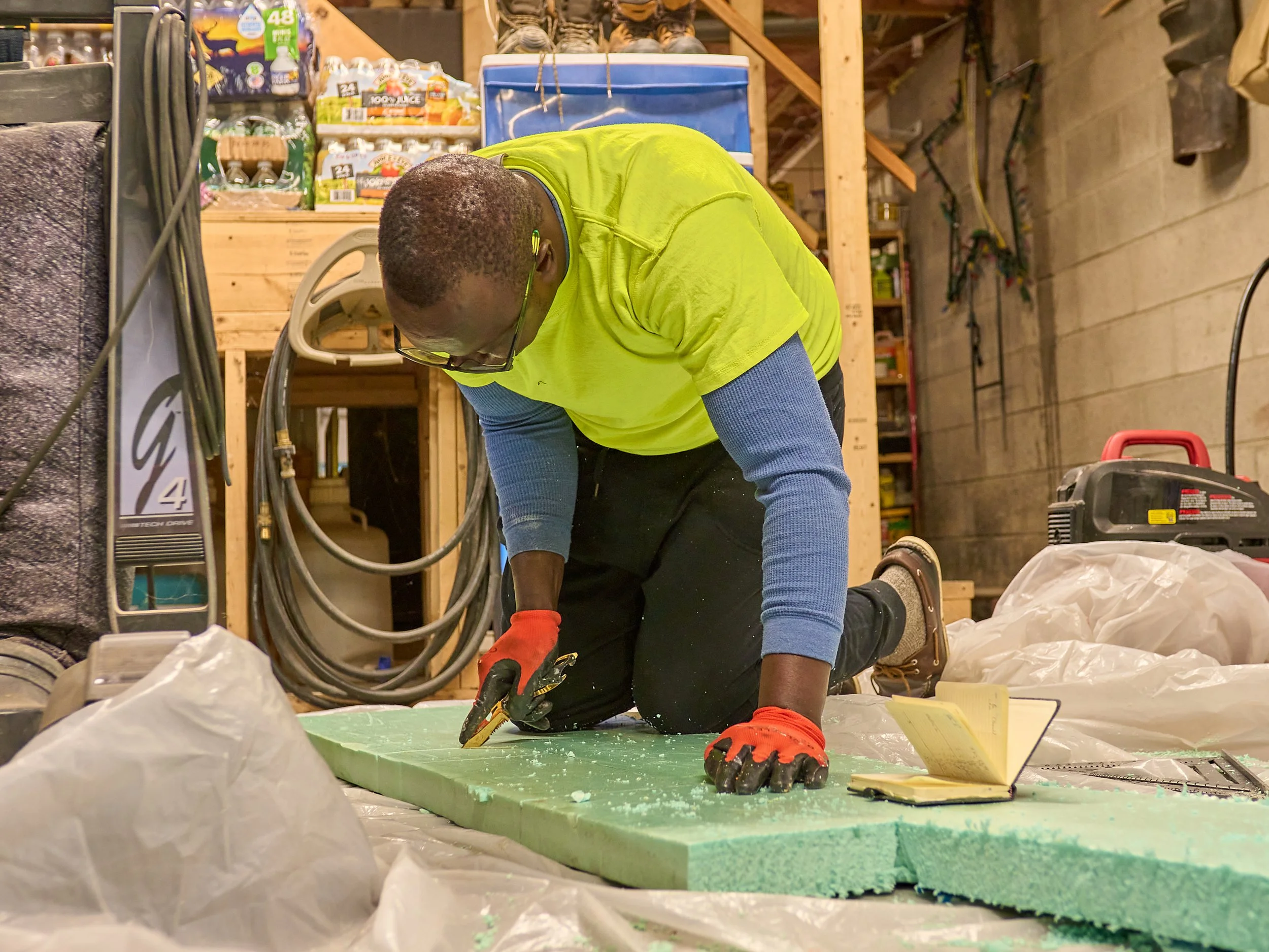 Man cutting foam board insulation with a knife.