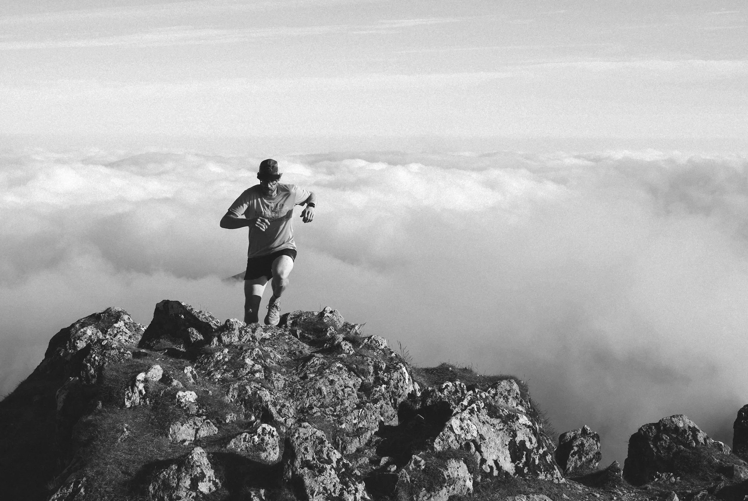 a man running up to the top of a rocky hill