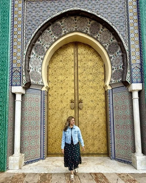 Ornated carved golden doorway with traditional Moroccan tilework in Fez