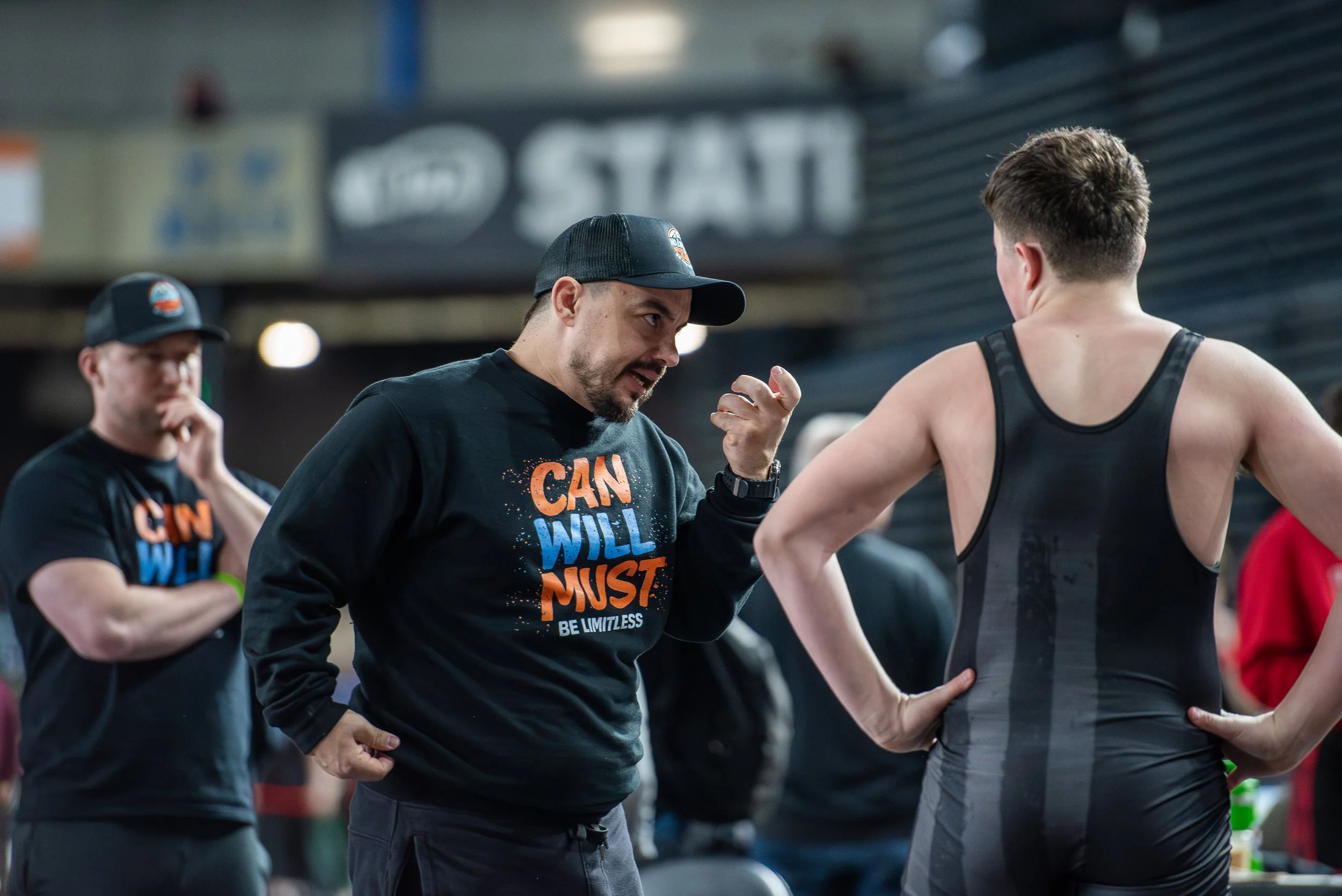 Wrestling coach talking with youth athlete during practice about development and support in youth sports
