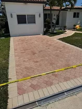 Residential paver driveway after pressure washing and re-sanding in North Bay Village, FL