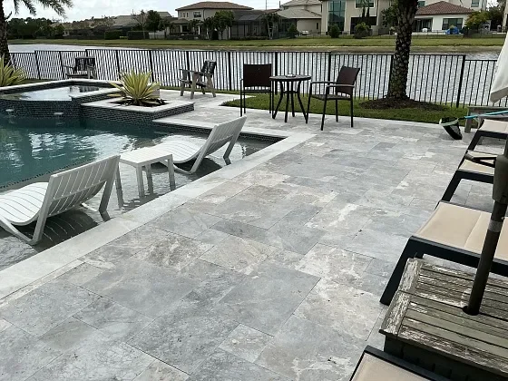 Modern pool deck restoration with light stone pavers in Miramar, FL