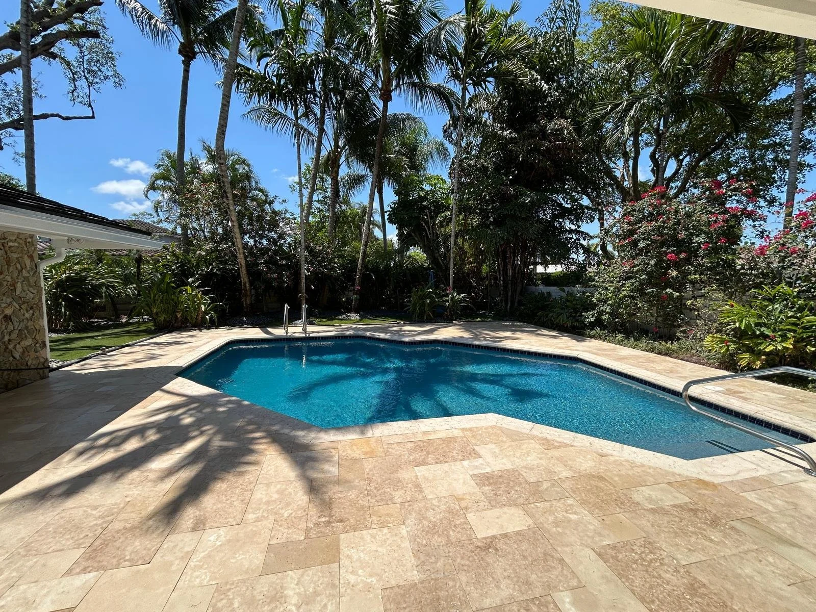 pool deck with textured pavers surrounding a backyard pool in Parkland, FL