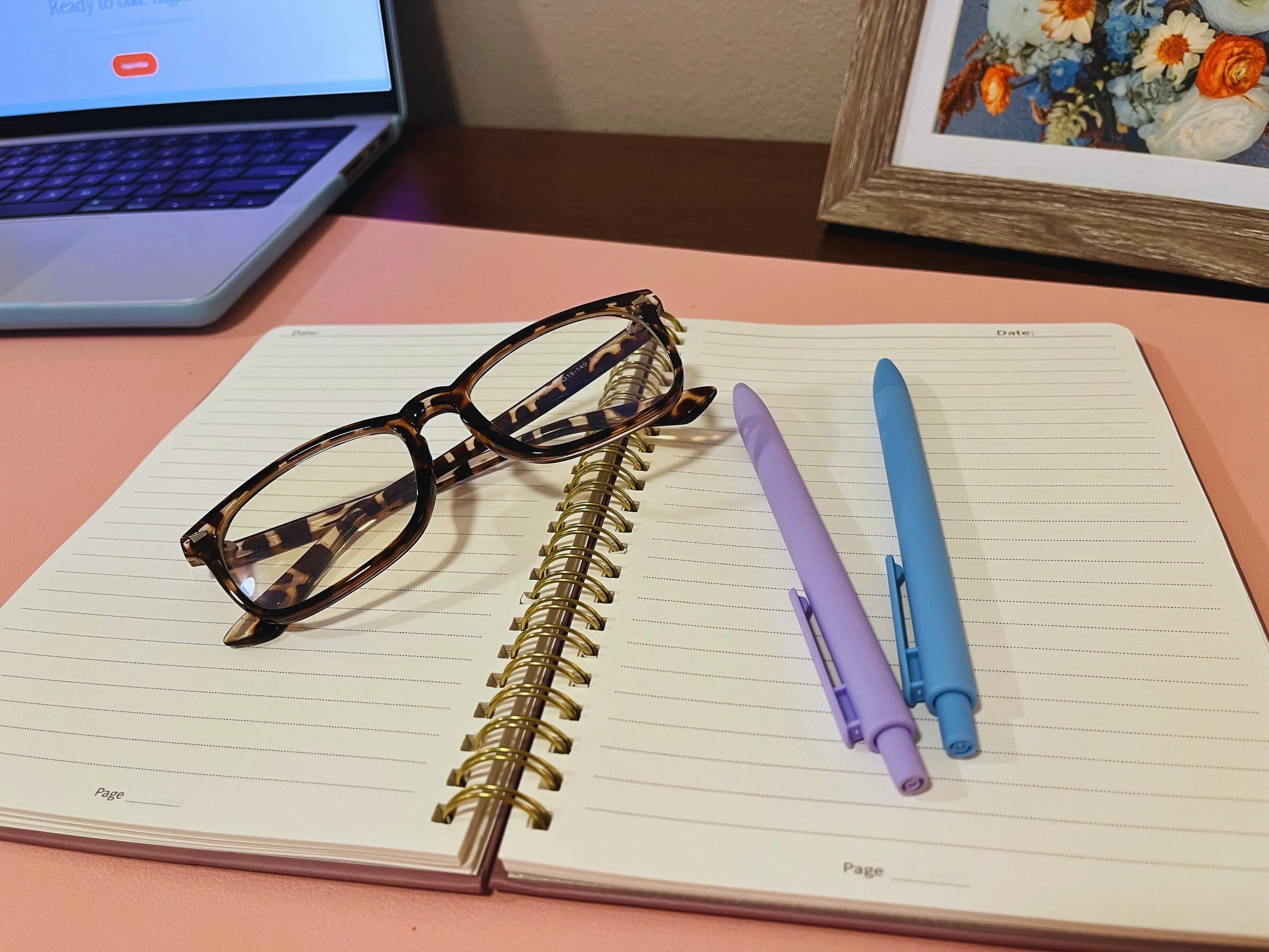 Image of notebook, pens, and glasses to represent marketing strategies.