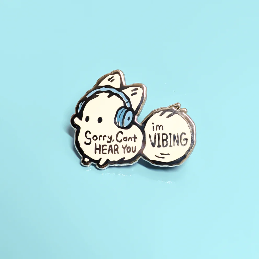 A pin featuring a cartoon character with a bow and headphones, with text saying "Sorry. Cant HEAR YOU," and a speech bubble with the words "im NIBING" on a light blue background.