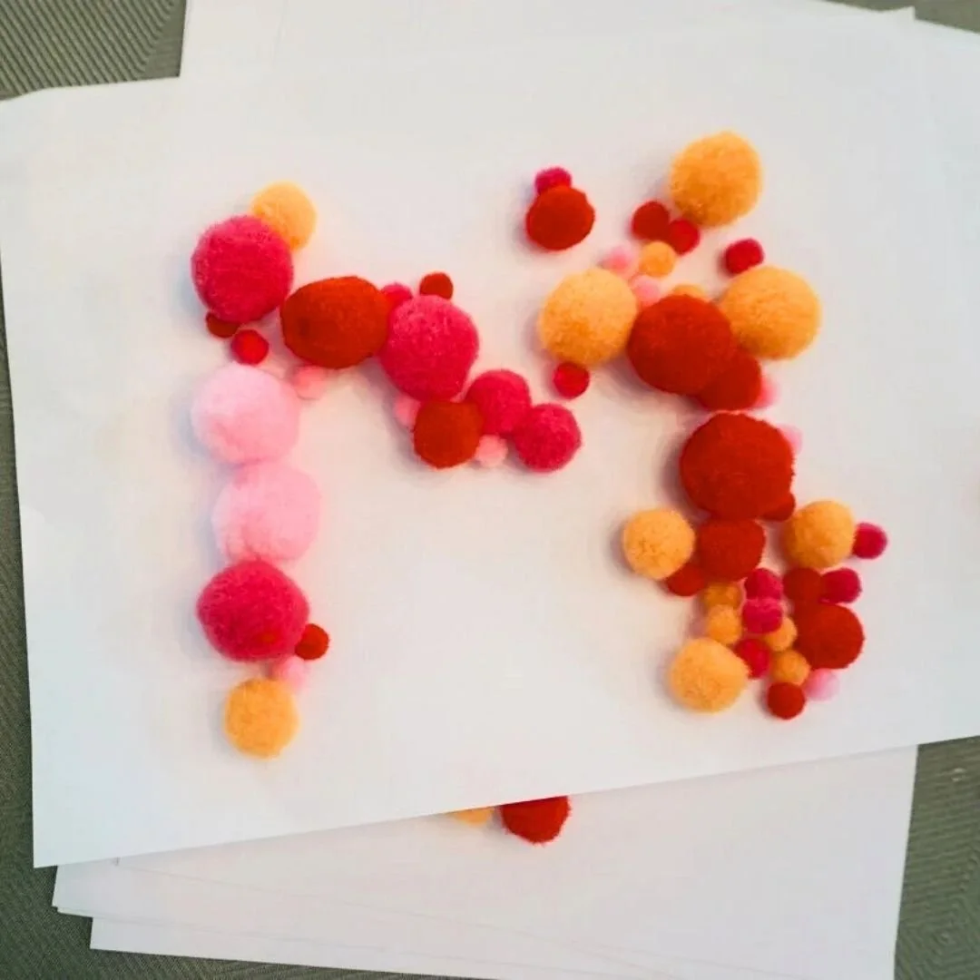 pom poms glued to sheet of white paper