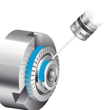 Close-up of a mechanical device with a syringe administering a liquid into a small circular opening.