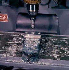 A CNC milling machine cutting a metal workpiece.