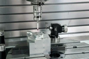 Close-up of a coordinate measuring machine (CMM) with a probe touching a metal workpiece.