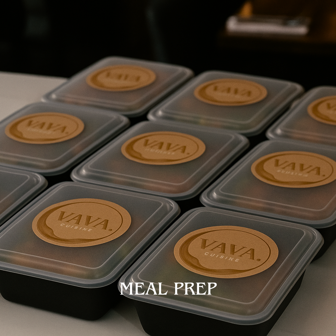 Multiple black meal prep containers with beige round labels that say 'VAVA CUISINE' arranged on a table.