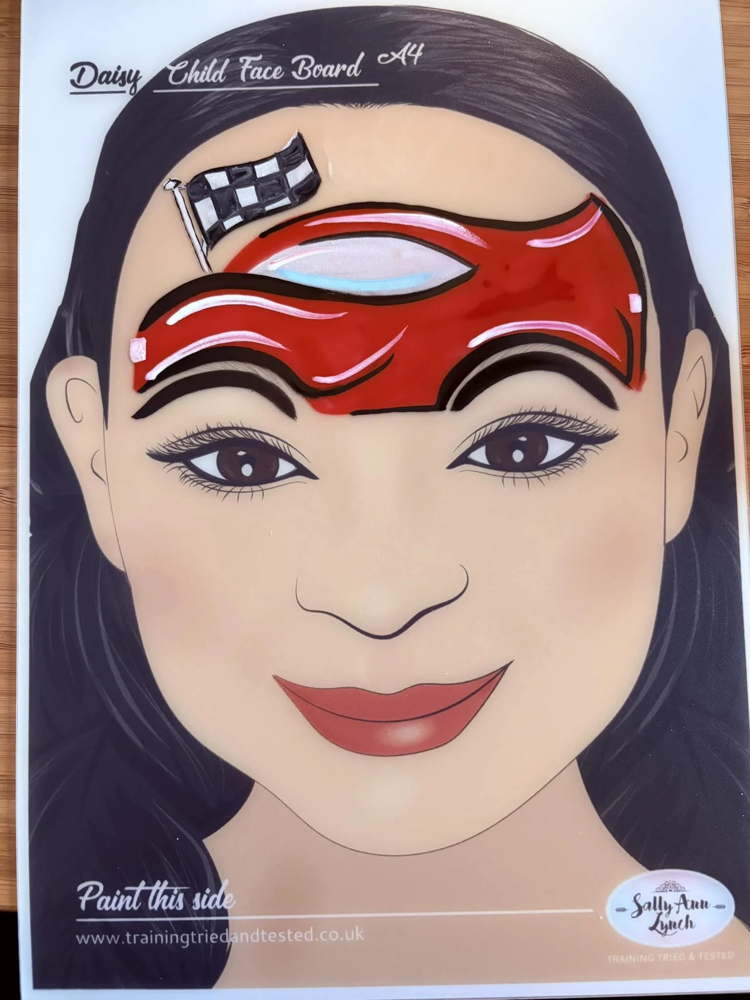 Red race car face paint on child