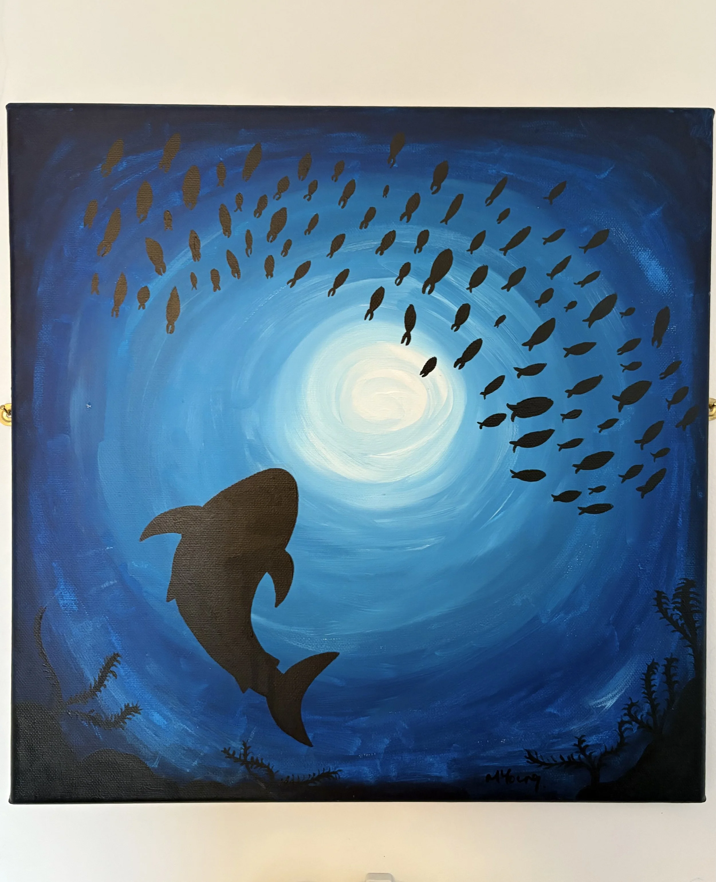 Acrylic on canvas painting of a large shark swimming in the ocean near the ocean floor with a school of smaller fish swimming above it, with a glowing light source in the background.