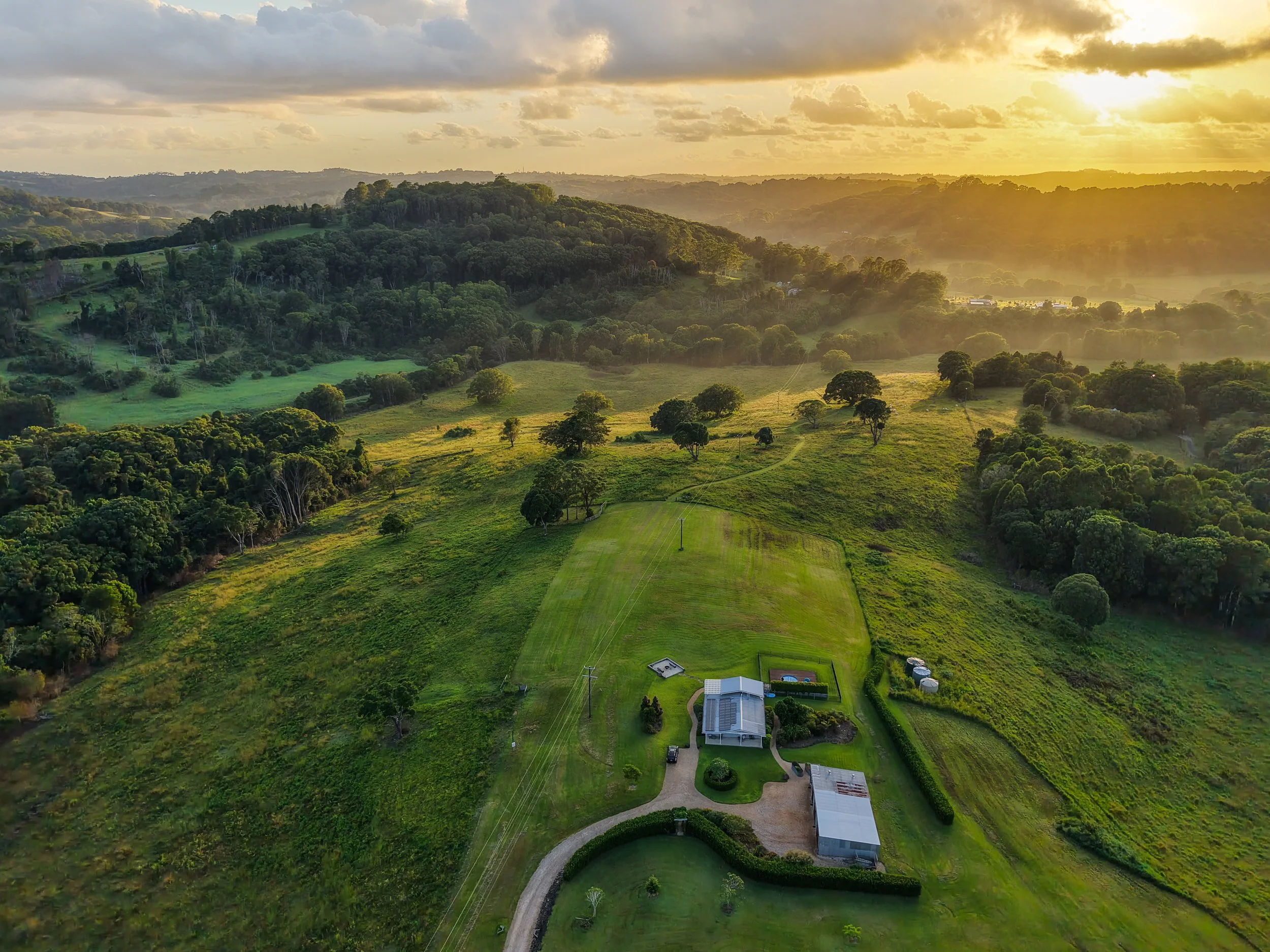 Rolling green hills and sunset over Heartwood Farm Byron Bay Hinterland, private luxury retreat setting