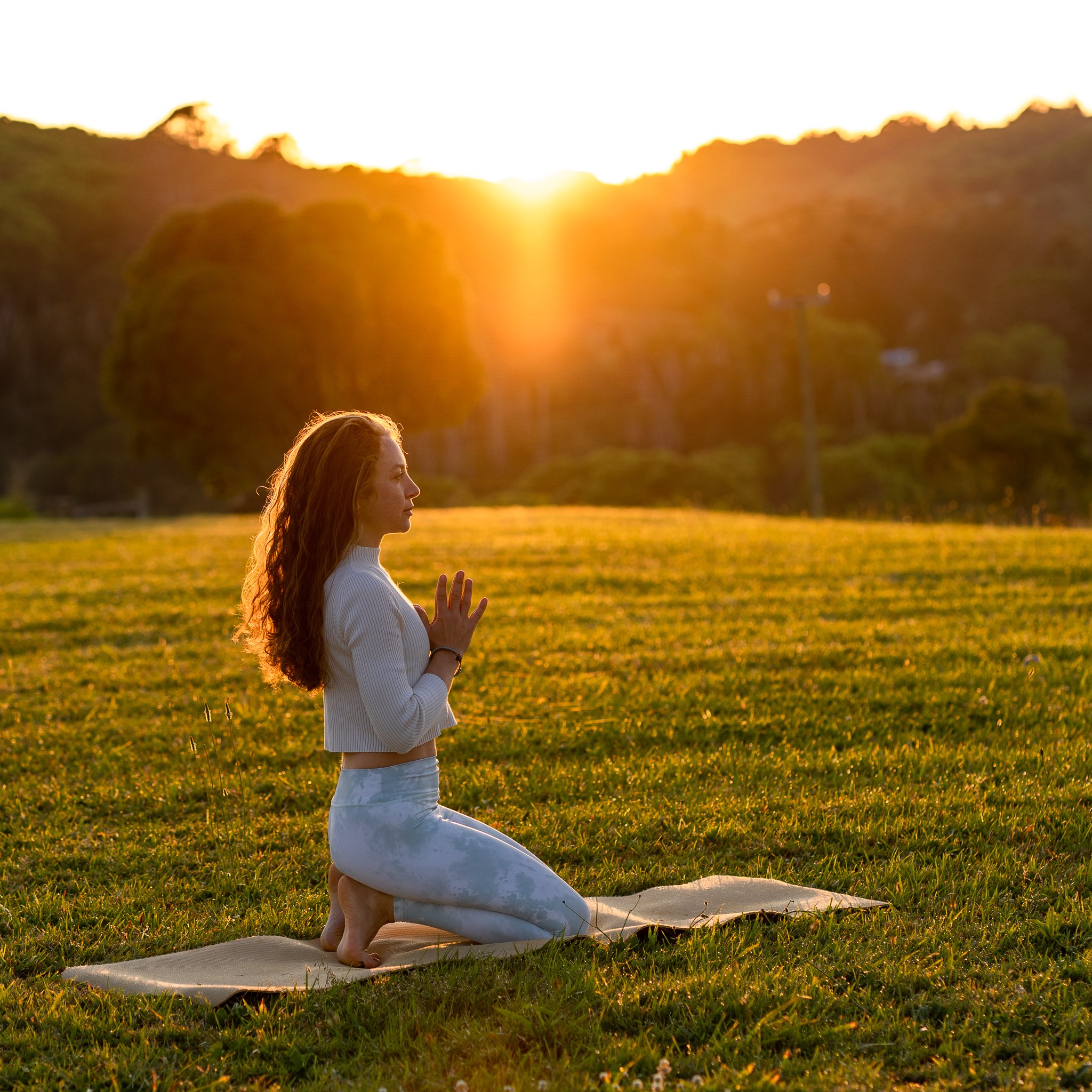 Woman in meditation at sunset during a private luxury wellness retreat in the Byron Bay Hinterland