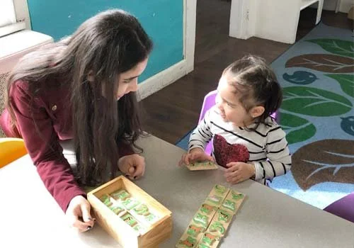 Teacher and child at table learning