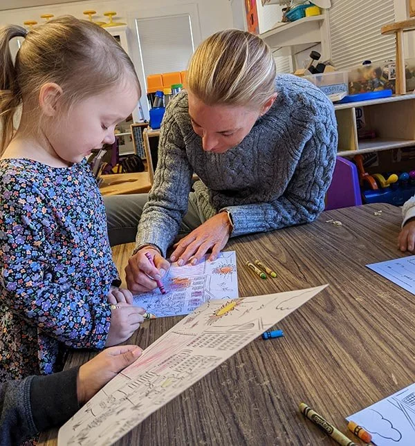 PNS teacher or volunteer coloring with child