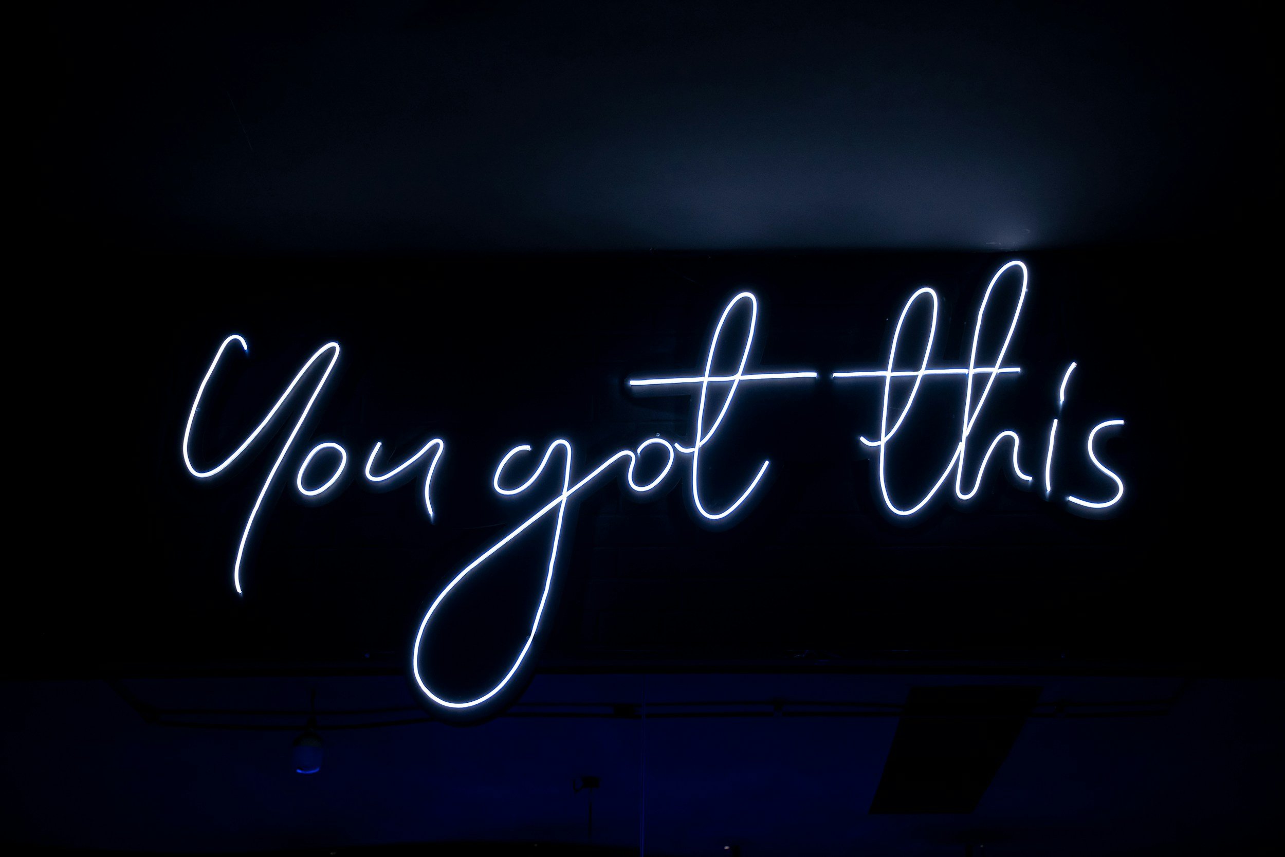 Neon sign that says "You got this" in cursive script on a dark background.