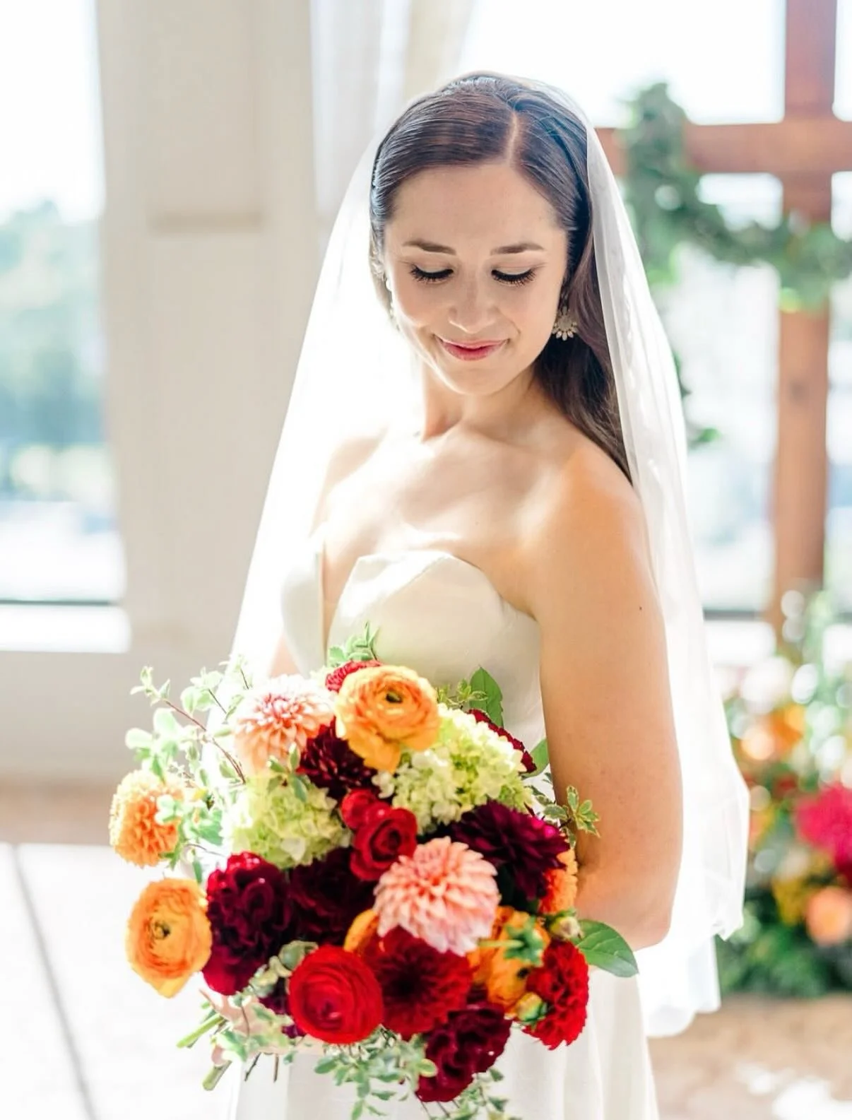 Elegance and warmth on display. For this beautiful bride, we designed a sophisticated look featuring a sleek, center-parted style and a makeup application focused on flawless skin and defined eyes. Everything about her look, from the understated jewe
