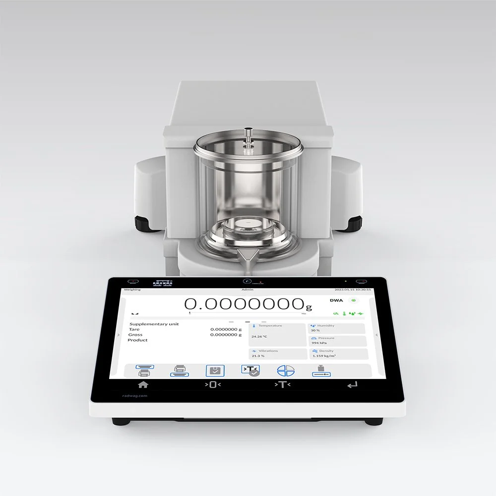 A modern, white digital laboratory scale with a digital display and a metallic cylindrical container on top, used for precise measurements.