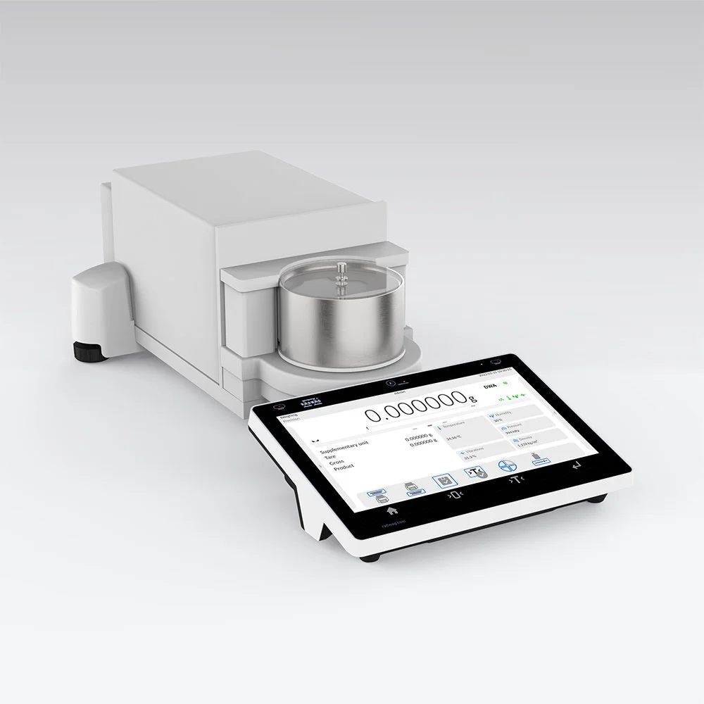 A digital weighing scale connected to a lab instrument, both on a white surface.