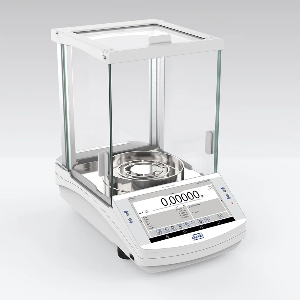 A digital analytical balance scale with a glass enclosure, a metal weighing pan, and a touchscreen display.