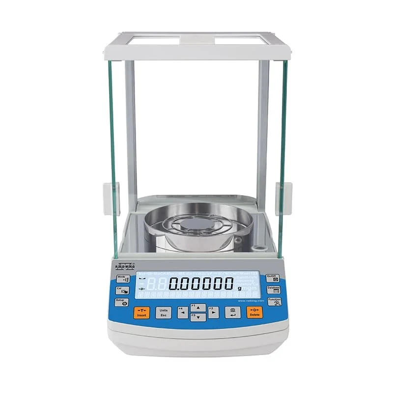 A laboratory electronic balance scale with a clear glass enclosure and a round metal weighing pan.