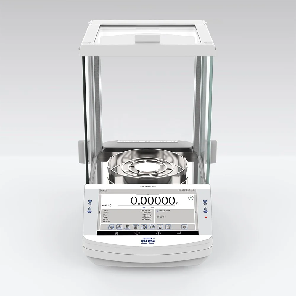 Lab scale with digital display showing zero weight, stainless steel weighing pan, and transparent protective cover.