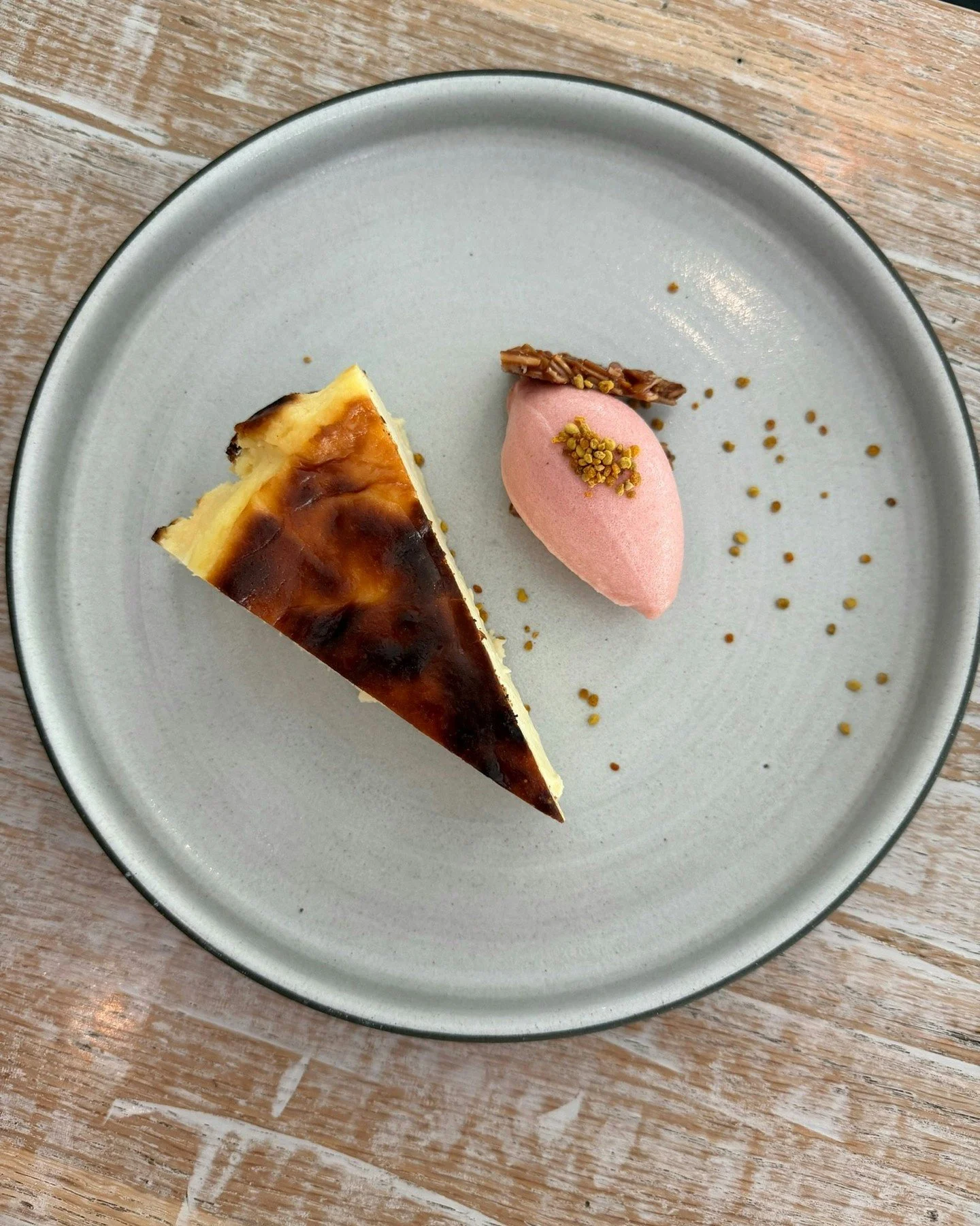 This unbelievably good Basque Cheesecake is creamy &amp; custardy with a crisp caramelized top. Served with bee pollen, almond brittle, and a tart rhubarb sorbet. 

You have to try it for yourself! Link to reservations in bio.