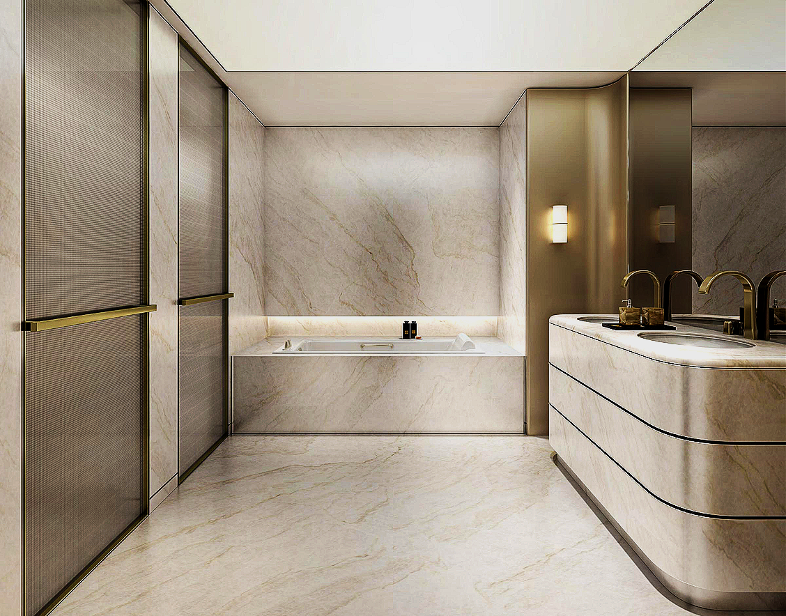 Modern bathroom with marble walls and floor, a built-in bathtub with black bottles, and a curved vanity with two sinks and gold fixtures.