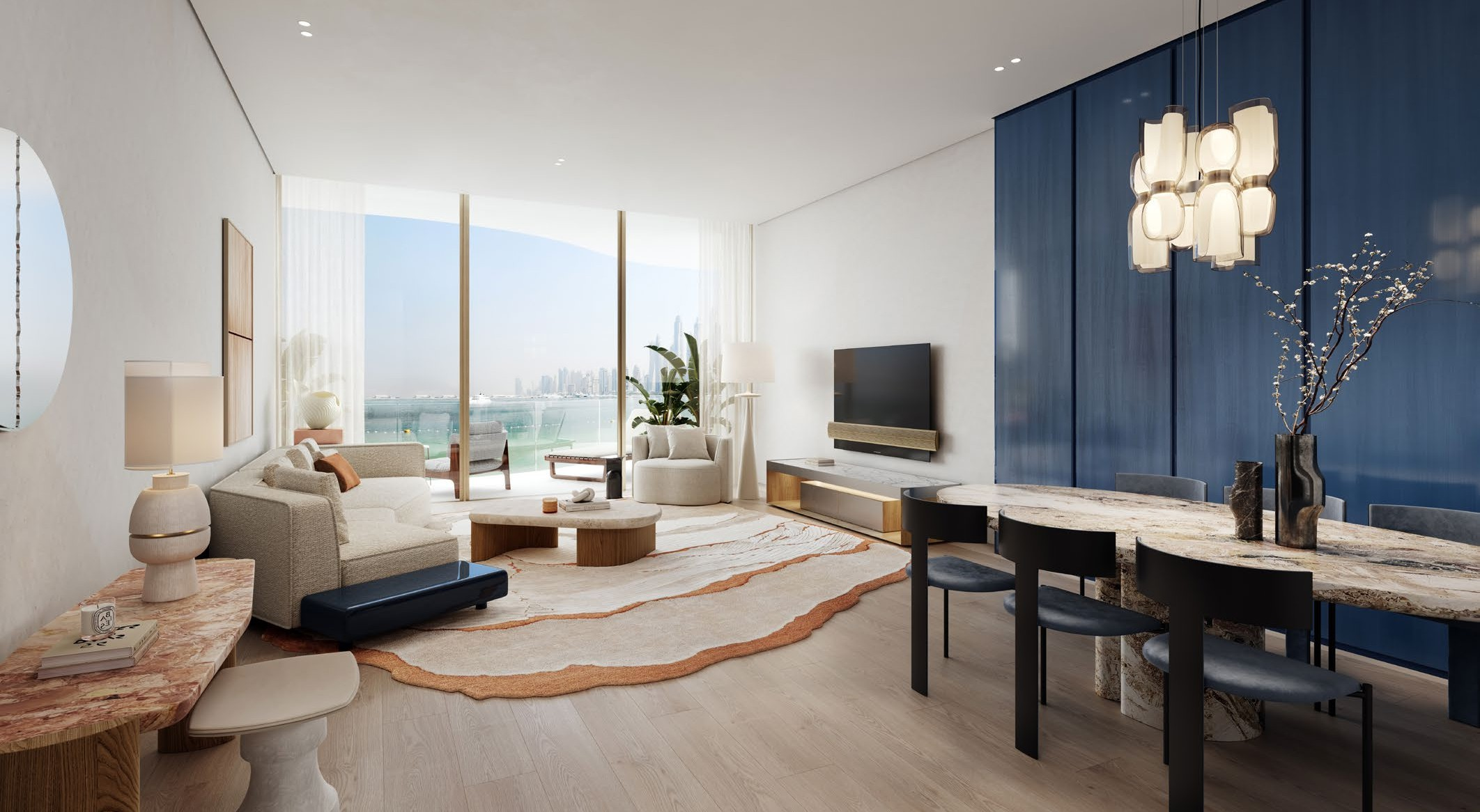 Modern living room with a large window view of a cityscape. Features include a white sofa, armchair, round coffee table, abstract area rug, blue accent wall, marble dining table with black chairs, and decorative vases with branches.