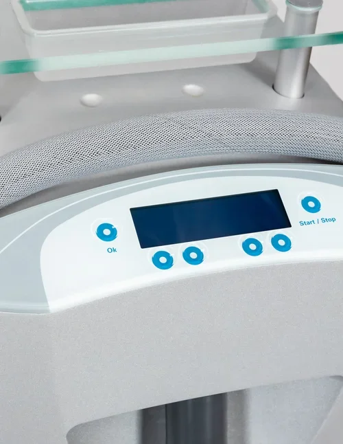 Close-up of a medical device control panel with a digital screen and six blue buttons labeled 'OK', 'Start/Stop', and others, in a clinical setting.