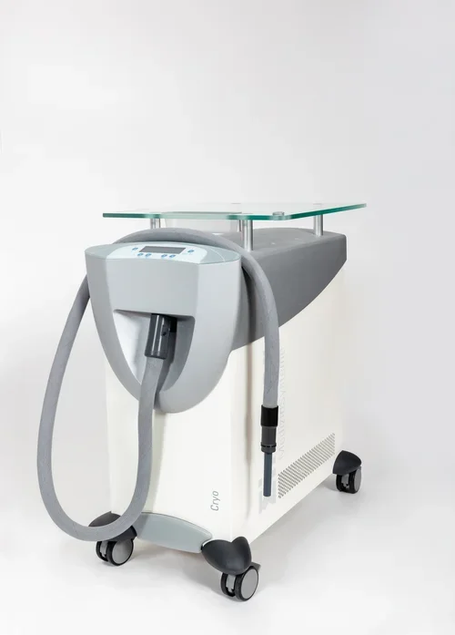Medical cryotherapy machine with a glass top and hoses attached, on wheels