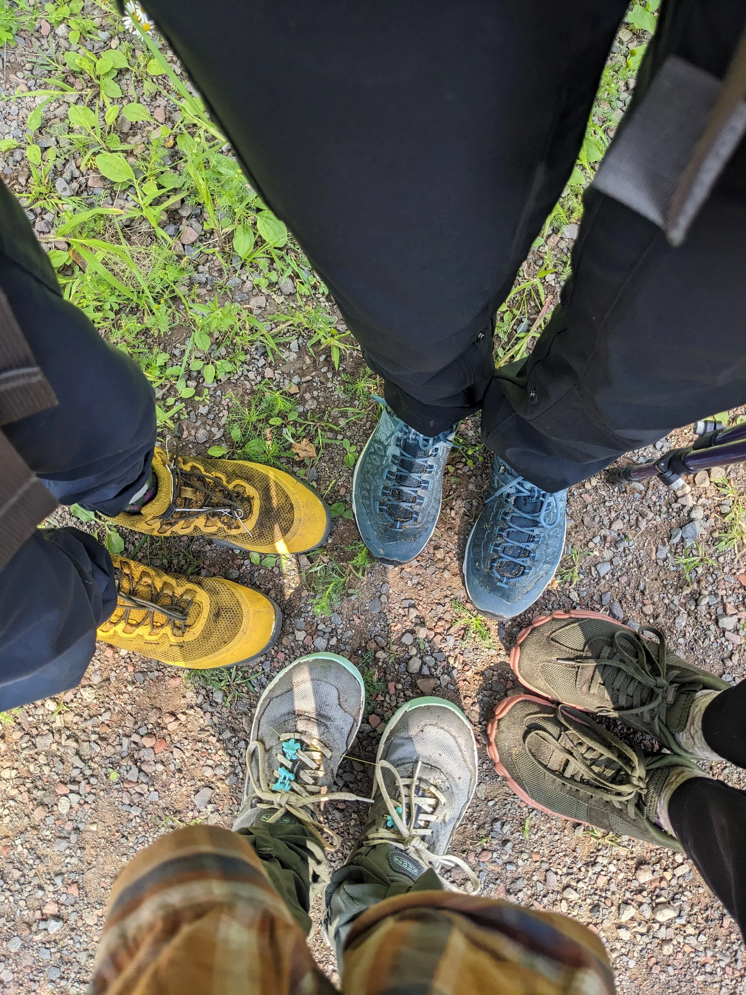four pairs of muddy hiking boots on the superior hiking trail in minnesota