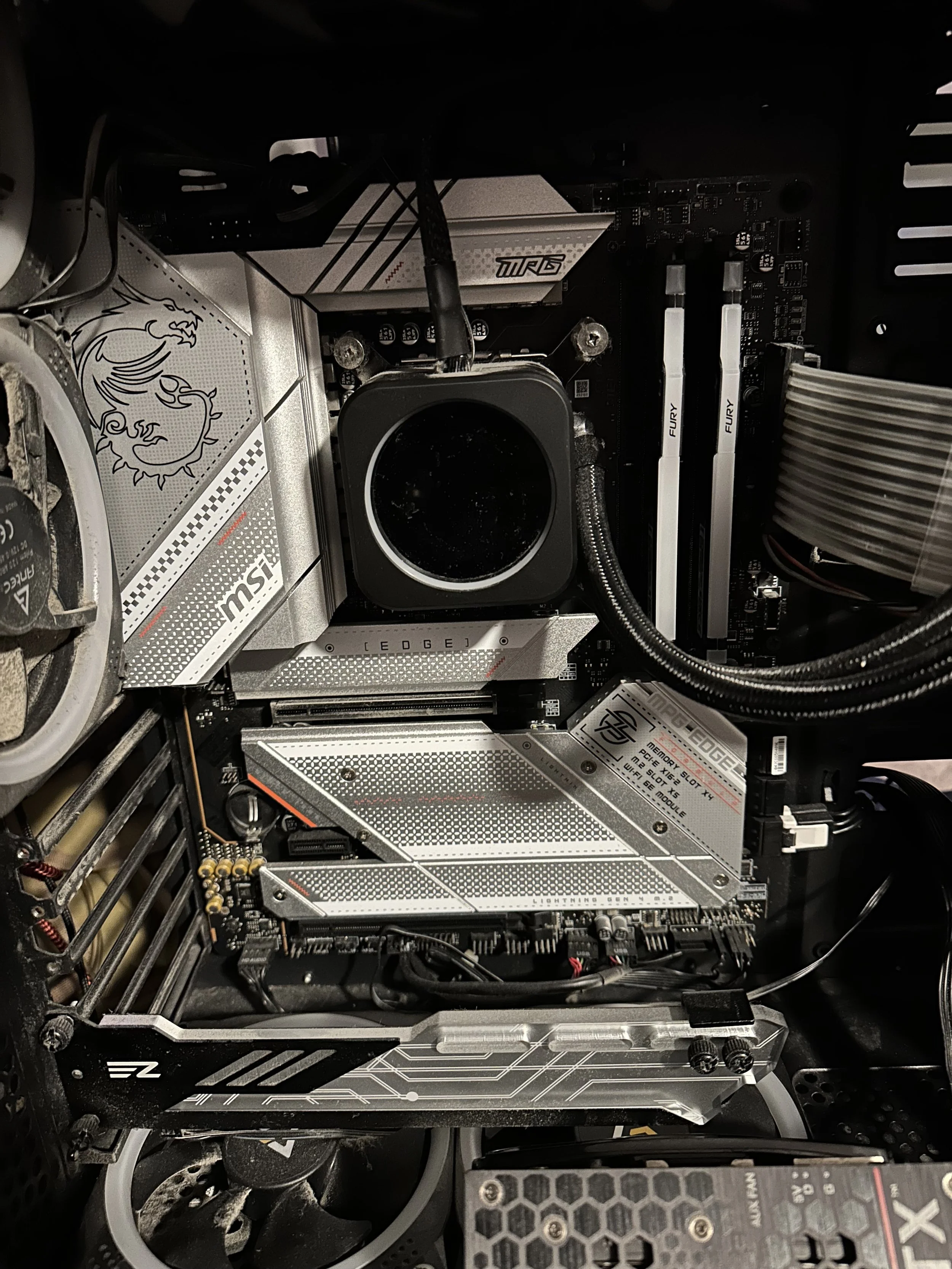 Inside a computer case with a motherboard, CPU cooler, RAM, and various components visible.
