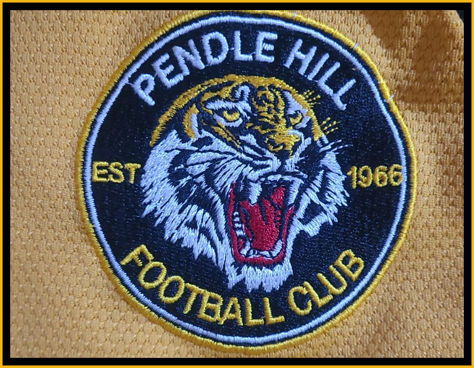 Pendle Hill Football Club patch featuring a fierce tiger head with an open mouth, in yellow, black, white, and red embroidery.